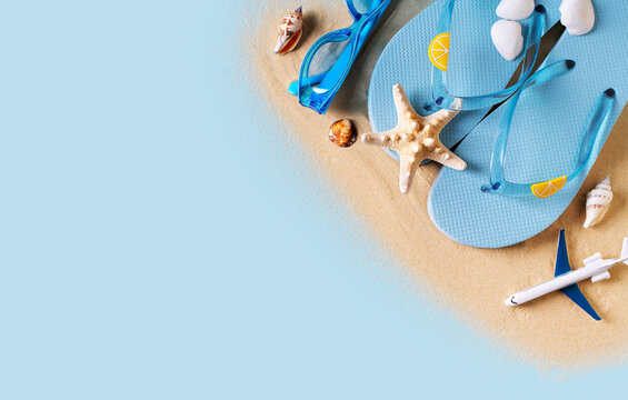 Summer holidays flat lay with shells, starfish and accessories on blue background