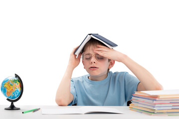 Exhausted boy closed his eyes and holds open book on his head. Learning difficulties. Distance learning education.