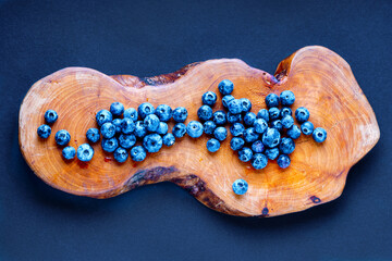 Ripe blueberry on a wooden slab board. Top view.