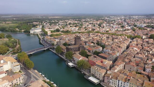 Bird's eye view of Agde, southern France. Residential buildings and Herault River visible from above.