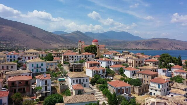 Aerial drone video from picturesque and traditional historic village of Galaxidi featuring landmark church of Agios Nikolaos, Fokida, Greece