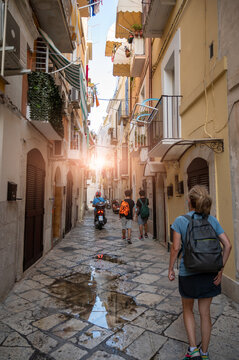 Bari, Puglia, Italy. August 2021. Tourists in the alleys of the historic center, the Bari Vecchia, full of charm and fascinating views. Paved street and out of the houses on the street.