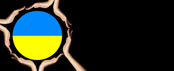 Human hands holding Ukrainian flag on black background