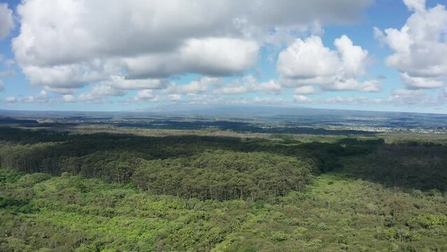 Wide aerial panning shot of both Mauna Loa and Mauna Kea volcanoes with their summits hidden by clouds on the Big Island of Hawaii. 4K