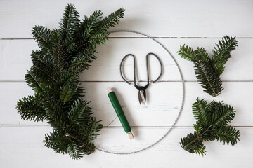 Making of wreath with wire, thread and spruce twigs