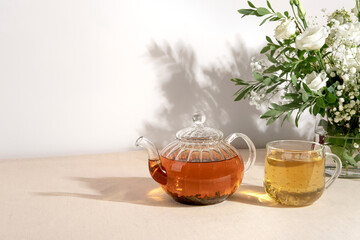 Green tea oolong in glass teapot on table. Hot tea is in the glass cup.