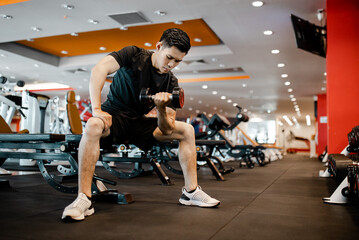 Asian young man using dumbbell exercise at gym for good healthy in fitness, Lifestyle and sport exercise concept.