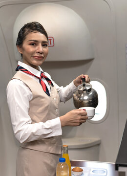 Asian Female Cabin Crew Preparing Coffee Serving On Plane