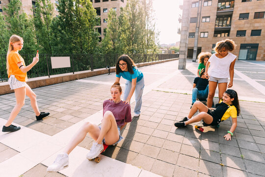 Girls skateboarding enjoying with friends at parking lot