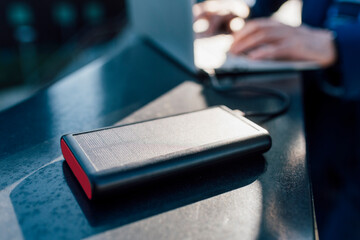Solar battery charger connected to laptop being used by businessman