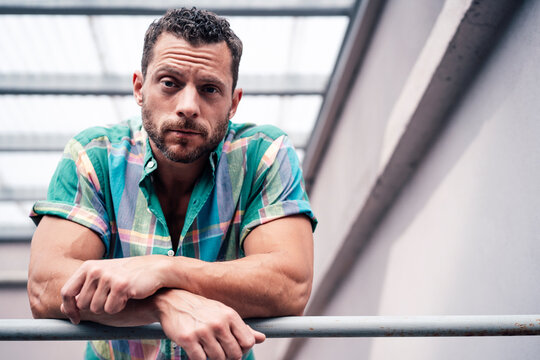 Mature man wearing shirt leaning on railing