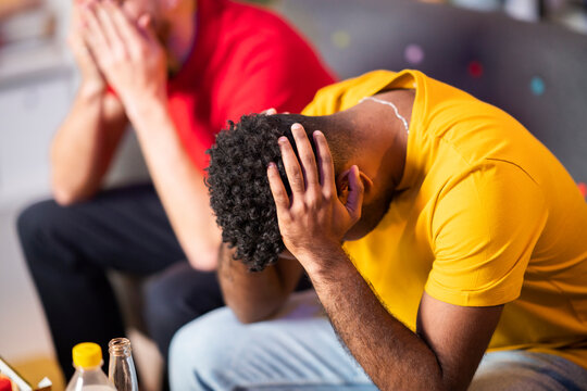 Sad Man Sitting With Head In Hands By Friend At Home