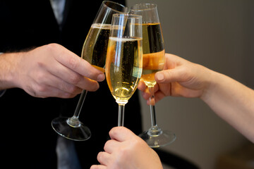 Cropped image of male hand holding glass glasses of wine in the hands of the business team