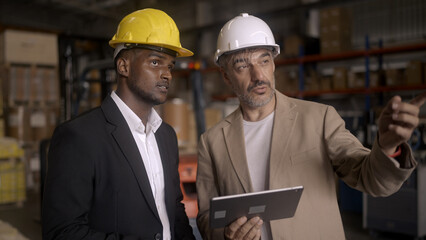 Businessman checking warehouse with staff
