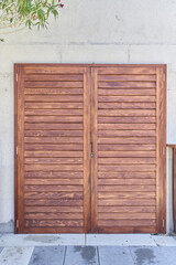 Small wooden louvered doors on a stone wall