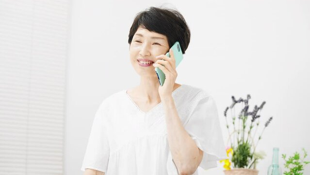 スマートフォンで通話をするミドル女性