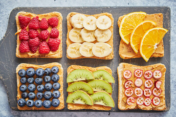 Wholegrain bread slices with peanut butter and various fruits
