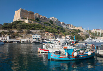View across harbour to the historic citadel, colourful fishing boats in foreground, Bonifacio, Corse-du-Sud