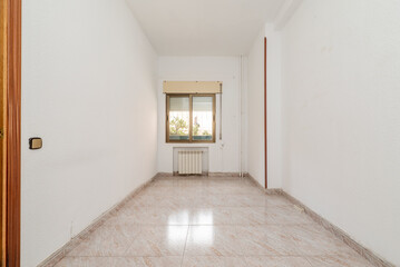 empty room with ceramic tile floors, gold aluminum window and white painted walls