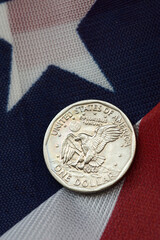 one dollar coin on american flag