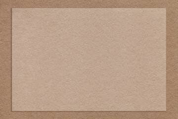 Texture of craft beige color paper background with brown border, macro. Structure of vintage dense kraft cardboard