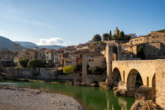 Besalu historic medieval city with Catalonia flags on the stone bridge tower crossing El Fluvia river, Besalu, Catalonia