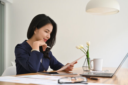 Attractive Young Businesswoman Analyzes Monthly Reports At Her Modern Office