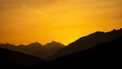 Mountain landscape panorama background - Sunrise with silhouette of mountains and orange sky