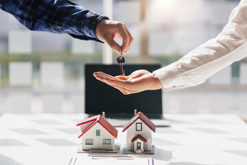 The real estate agent hands the customer the keys to the house after the contract agreement is...