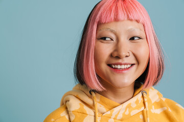 Asian girl with pink hair and piercing laughing while looking aside