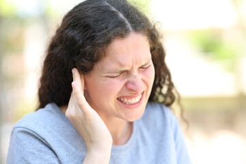 Woman complaining suffering ear ache - obrazy, fototapety, plakaty