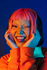 Asian girl with pink hair winking and showing her tongue