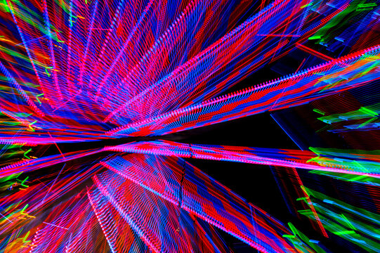 A ferris wheel at night, light patterns, red, blue and green
