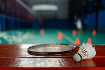 Badminton shuttlecock and racket with blur player background