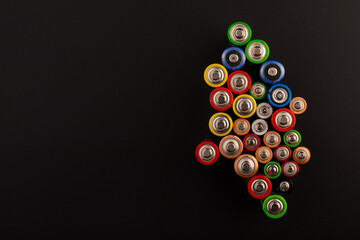 Composition with alkaline batteries on black background. Chemical waste. Top view