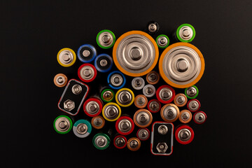 Composition with alkaline batteries on black background. Chemical waste. Top view