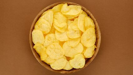 Potatoes chips in wooden bowl, top view 