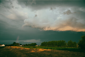 Fototapeta na wymiar Dramatic sky with thunderstom over small village in Transylvania.