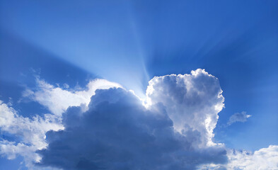 Single cloud in the blue sky with sun rays