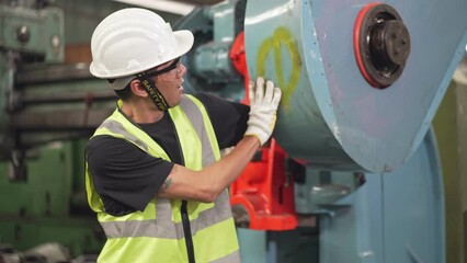Asian male factory worker having accident arm stuck in the machine while working at industry construction site. working in danger area. life insecure and protection concept
