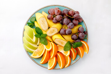 Beautifully cut fruit on plate on white background