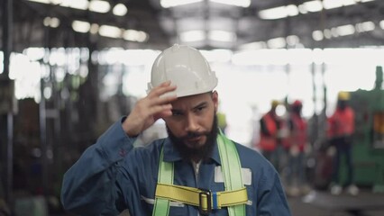 Male engineer or technician worker in safety uniform wearing hardhat and protective eyeglasses walking in the industrial factory. Confident mechanic man working at construction site - Powered by Adobe