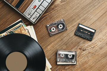 Vinyl records, cassette tapes and cassette recorder. Retro music style. 80s music party. Vintage...