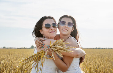 Two smiling female friends in the wheat field