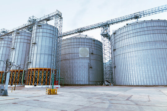 Modern Granary elevator. Silver silos on agro-processing and manufacturing plant for processing drying cleaning and storage of agricultural products, flour, cereals and grain. High quality photo
