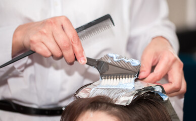 Hairdresser stylist takes care of girl's hair. Hair care procedures in a beauty salon. Hair...