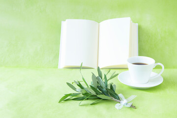 コーヒーと本と白いリボンをつけたオリーブの小枝のグリーンブーケ（グリーンバック）	