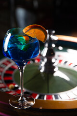 Blue alcoholic cocktail. Against the background of the roulette wheel.