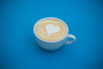 A cup of cappuccino on a blue surface.