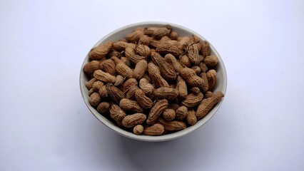 a bowl of roasted peanuts on a isolated background